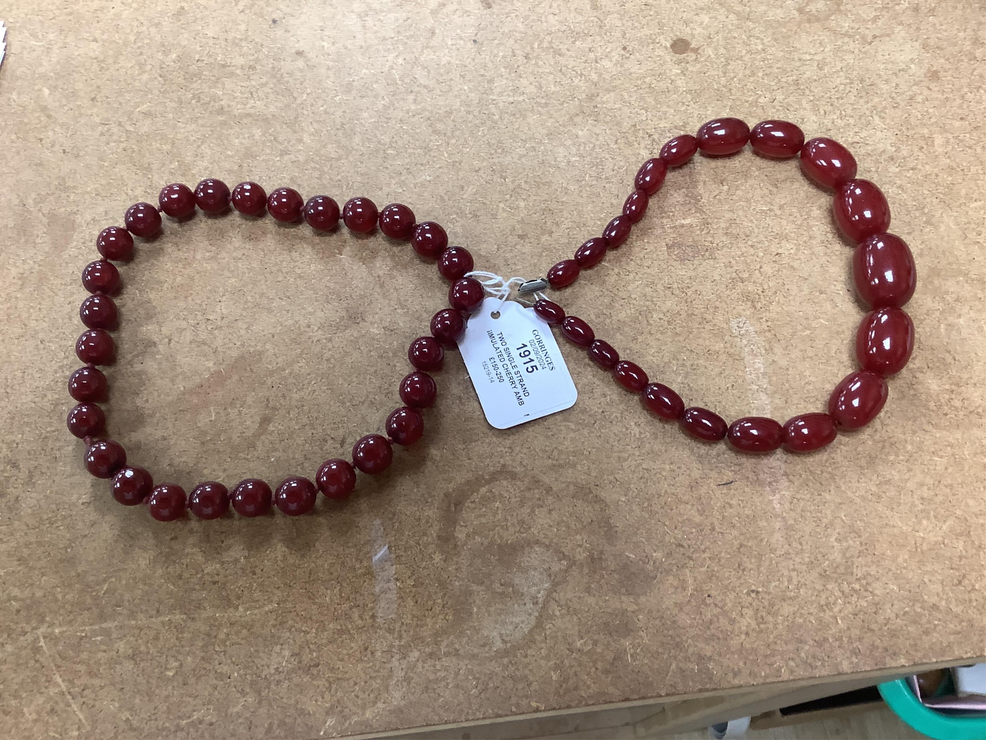 Two single strand simulated cherry amber necklaces, longest 42cm, gross weight 127 grams. Condition - fair